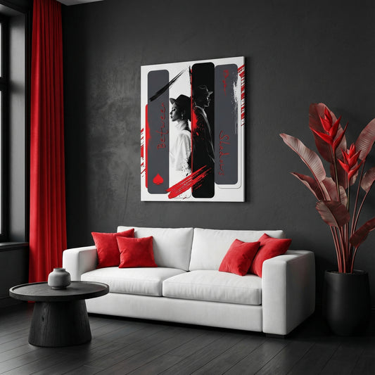 Modern living room with a white sofa, red pillows, and a black and white abstract painting on a dark wall.